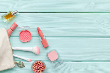 Layout of cosmetic bag with makeup brown pink shade beauty products, top view