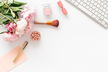 Flatlay office desk with pink peony flowers and female accessories