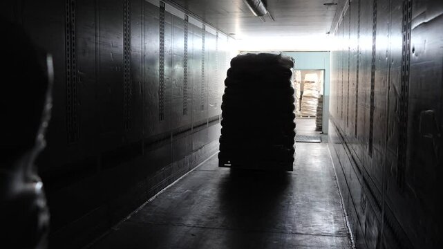 A forklift in motion, carefully loading a large product box onto a pallet