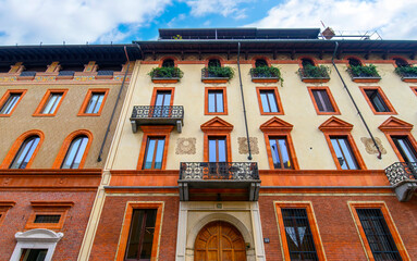 Obraz premium Milan, Italy. Traditional colorful building with balconies, shutter windows and multicolored walls in typical italian street 