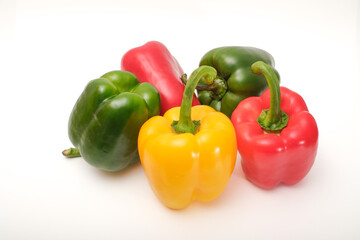 Red, yellow and green peppers on white background