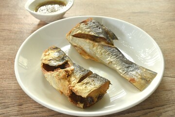 deep fried salty tiger fish dipping Thai spicy seafood sauce on plate