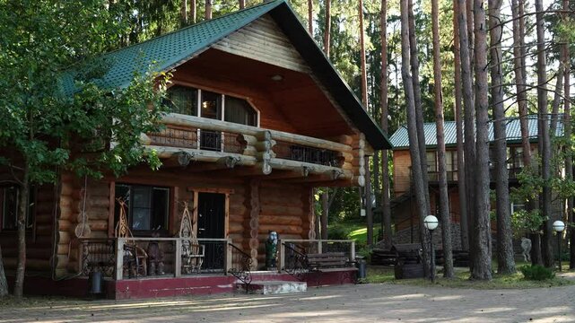 Wooden house in a tranquil pine forest, with balcony, terrace, and lush lawn. Surrounded by tall trees