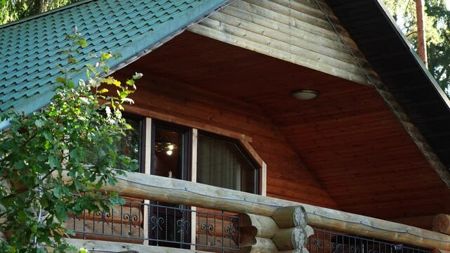 Wooden house in a tranquil pine forest, with balcony, terrace, and lush lawn. Surrounded by tall trees