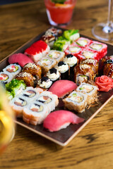Vibrant social setting with sushi and drinks, sushi lovers enjoying lively atmosphere, sushi platter as centerpiece of festive dining, enhancing communal experience