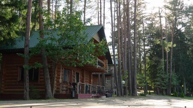 Wooden house in a tranquil pine forest, with balcony, terrace, and lush lawn. Surrounded by tall trees