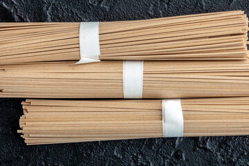 Soba, Japanese buckwheat noodles, on a black background, shot from the top