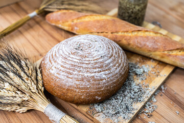 Freshly baked bread with dietary supplements on the table. Still life of bread, baguette, ears of corn, deer moss