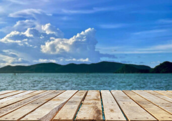 Fototapeta premium Wooden table top on the beach or sea.Party on the beach sunshine time concept.For montage product display or design key visual layout.View of copy space.