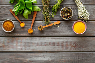 Frame of green herbs and spices in bowls for cooking, top view