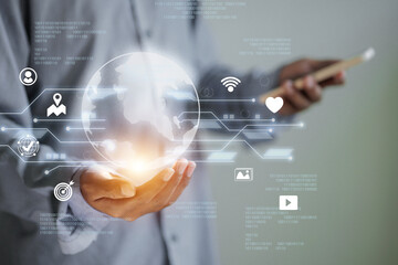 A person is holding a holographic globe with digital connections, representing global communication and technology
