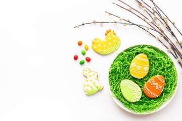 Festive Easter table setting with eggs cookies and willow branches, top view. Happy Easter concept