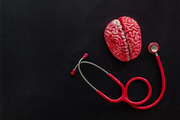 Human brain model with red stethoscope, top view. Mental health concept.
