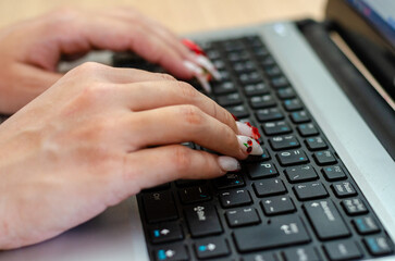 Close up image of a woman hands writing on a laptop