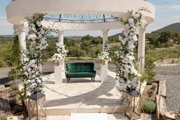 Elegant outdoor wedding gazebo with floral decor.
