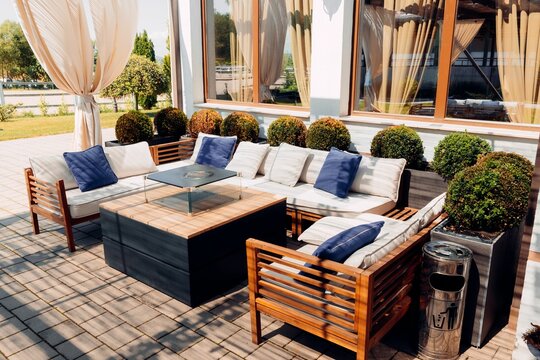 Stylish outdoor patio seating area with wooden furniture.