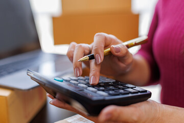 Young entrepreneur small business SME freelance press the calculator to account for receive order...