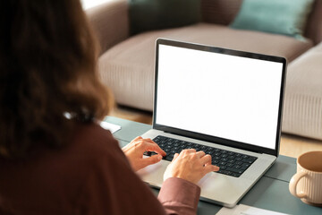 Over shoulder view of female freelancer business woman working remotely, looking at white blank mockup laptop pc screen for advertising. Student doing ai search online for it work or studying at home