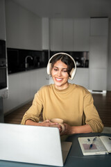 Vertical portrait of young smiling latin freelance businesswoman using computer app for remote...