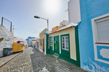 Obraz premium Road, stone or homes in city for architecture, buildings or lens flare in Spain. Santa Cruz, travel or cobblestone in neighborhood for heritage town, history or village design in Europe for aesthetic