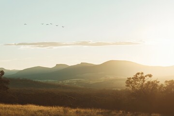 Photograph of a beautiful mountain range at sunrise, with a misty, snow-capped peak and muted, low-contrast colors