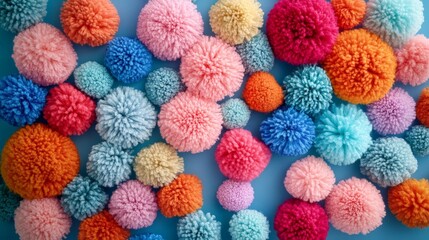 A vibrant collection of colorful pom poms arranged on a blue background for crafts