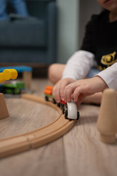 Child playing with wooden train on a track at home