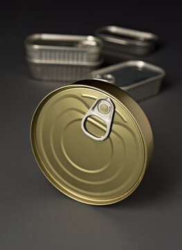 Close up of open and closed metal food cans on gray background