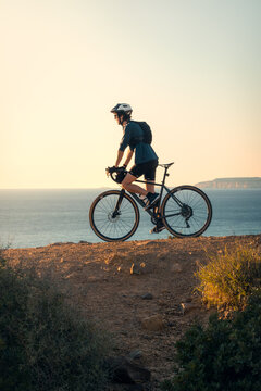 Young man cycling by the sea in Zahara de los Atunes, Cadiz