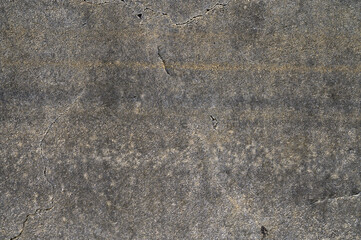 Surface textures showcase natural wear and tear in gray concrete under bright sunlight