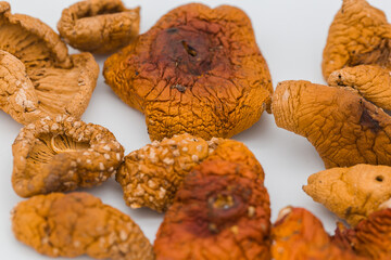 Dried red fly agaric mushrooms on a white background.
