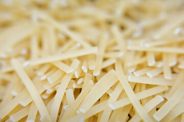 Raw yellow spaghetti pasta. Close-up, macro. Pasta on a white background. Uncooked italian uncooked pasta.