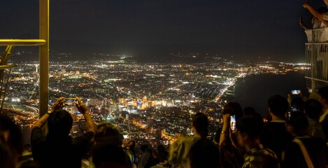 People taking pictures of a panorama of Hakodate City view from Mountain Hakodate, August, 2024. Japan. 