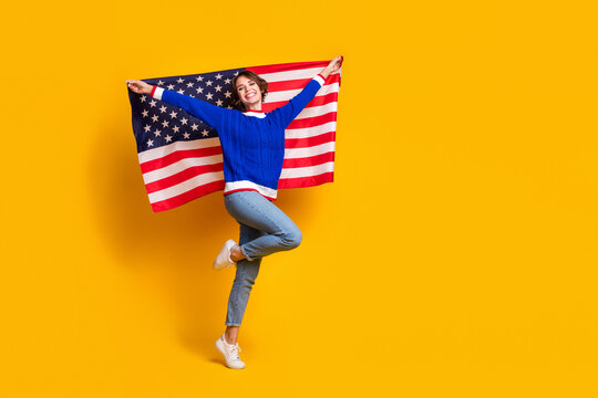 Full length photo of funky excited lady dressed knitted sweater holding american flag empty space isolated yellow color background