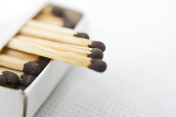 Matchsticks in a box. Matches with black heads. Matches with brown heads