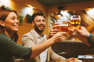 Cheerful businesspeople enjoying a celebratory toast with beer creating a joyful atmosphere at a pub restaurant