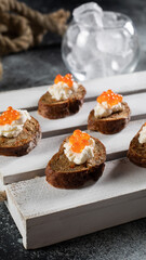 Small toasts with red salmon caviar on black bread