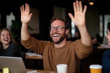 A cheerful man raises his hands in excitement, surrounded by laughing colleagues in an engaging and vibrant office environment that fosters teamwork and camaraderie.