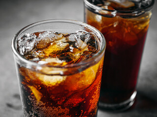 Cola soft drink with ice cubes, Close up of soda fizzy drink in Cold glass on gray background