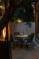 Elegant dining table set in a cozy restaurant with modern rustic decor. A beautifully arranged dinner setting featuring ceramic plates, glassware, and neatly placed cutlery. The warm ambient lighting 