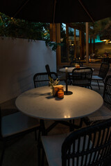 Elegant dining table set in a cozy restaurant with modern rustic decor. A beautifully arranged dinner setting featuring ceramic plates, glassware, and neatly placed cutlery. The warm ambient lighting 