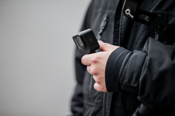 Man holding smart small pocket sized action camera. Marketer ready for mounting small action camera handheld
