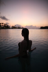 Fototapeta premium Woman in ocean during sunset
