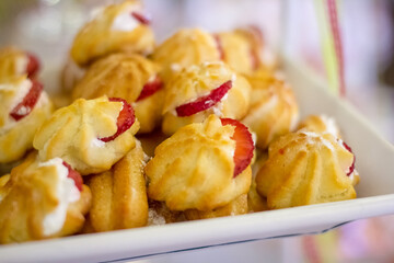  Close up of a plate of profiteroles with strawberries on top