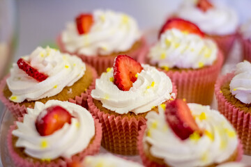  Cupcakes decorated with cream and strawberries on a white background