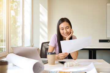 Female studies the design documentation with a smile