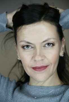 Portrait of attractive middle aged brunette woman 51 years old with evening make-up and natural hair styling