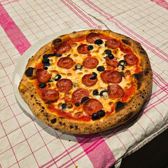 A Delicious and Flavorful Pepperoni Pizza with Olives Served on a Charming Rustic Table
