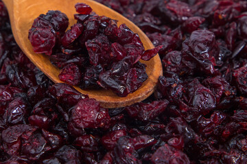 Dried cranberries in a wooden spoon. Selective focus.