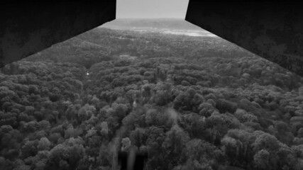 A grainy black and white film look view from inside a World War II plane carpet bombing the enemy landscape. Simulated.	